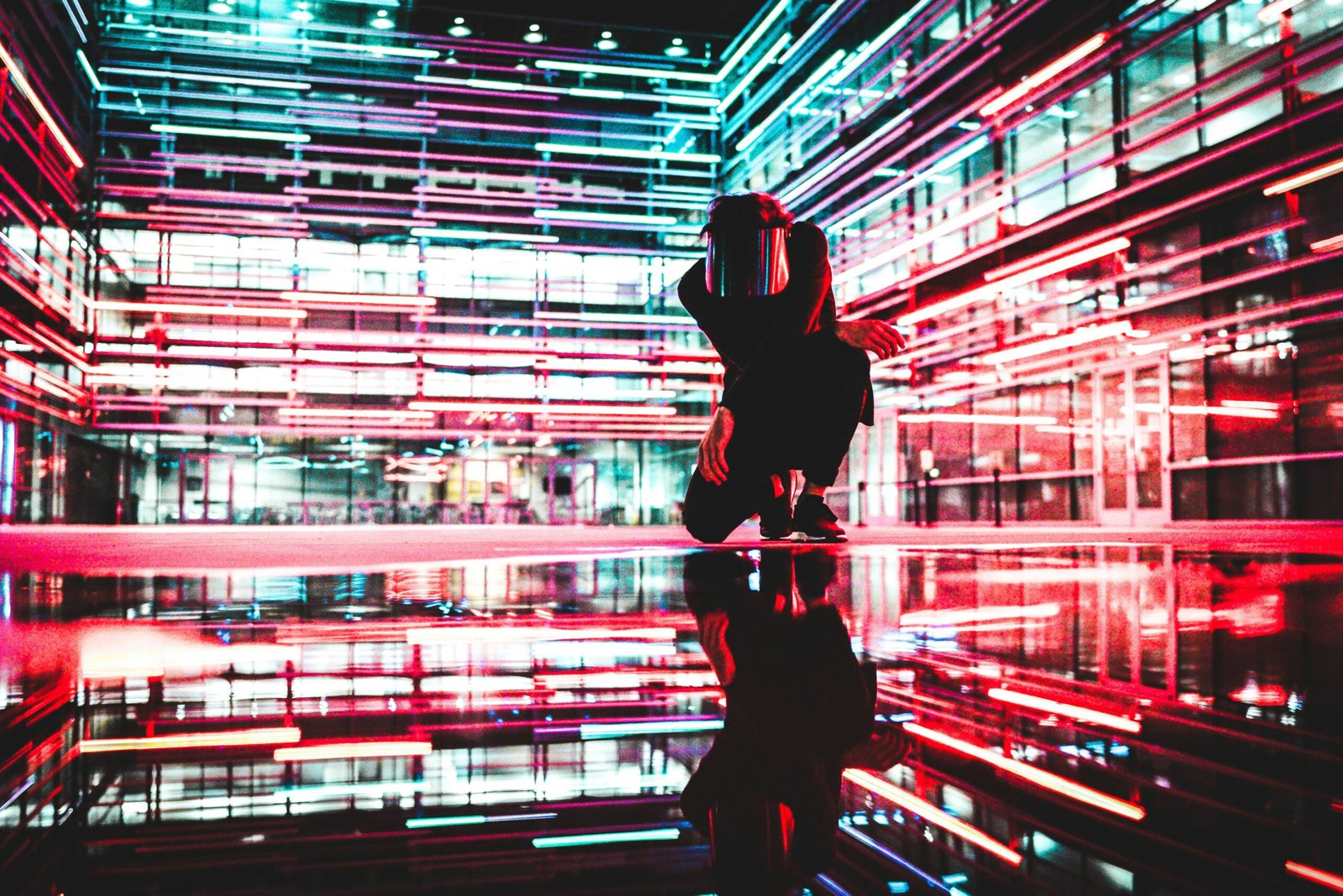 person kneeling in room of neon lights